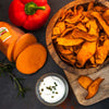 arrangement-suesskartoffelchips-mit-suesskartoffel-und-paprika-und-sauerrahm-auf-schneidebrett