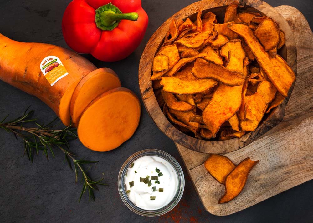 arrangement-suesskartoffelchips-mit-suesskartoffel-und-paprika-und-sauerrahm-auf-schneidebrett