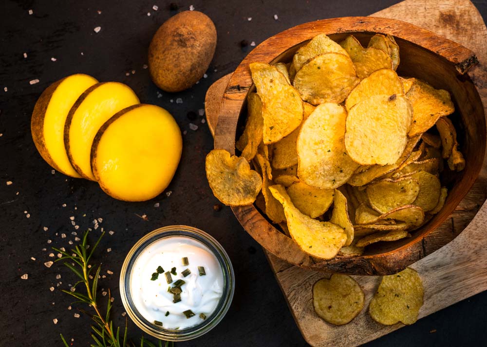 arrangement-kartoffelchips-mit-kartoffel-und-sauerrahm-auf-schneidebrett