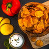 arrangement-kartoffelchips-mit-kartoffel-und-paprika-auf-schneidebrett