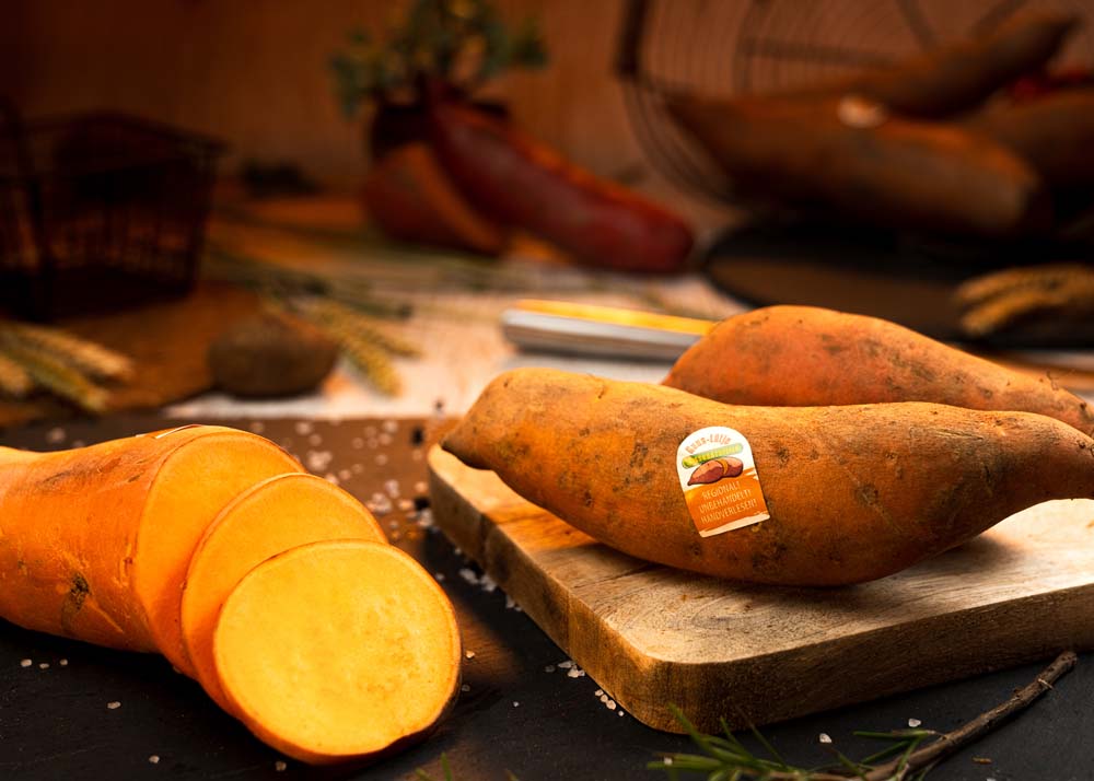 aufgeschnittene-suesskartoffel-orange-auf-schneidebrett